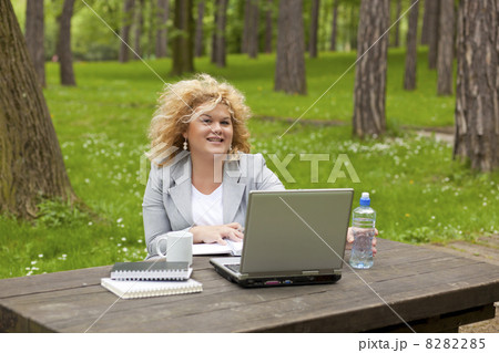 Woman using laptop in park 8282285