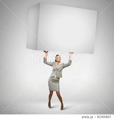 Businesswoman holding heavy cube Businesswoman holding heavy cube 8290865
