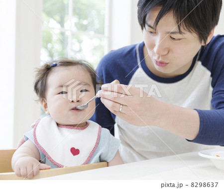 離乳食を娘に食べさせる父親 8298637