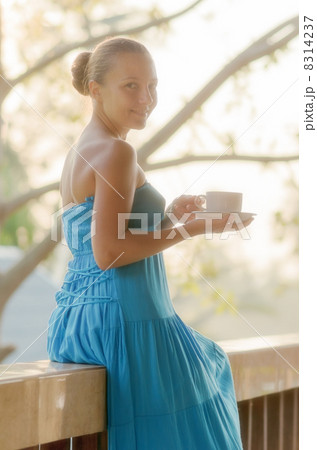Young woman drinking coffee on morning terrace 8314237