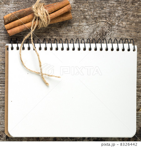 Blank Recipe book with bunch of cinnamon on old wood board 8326442