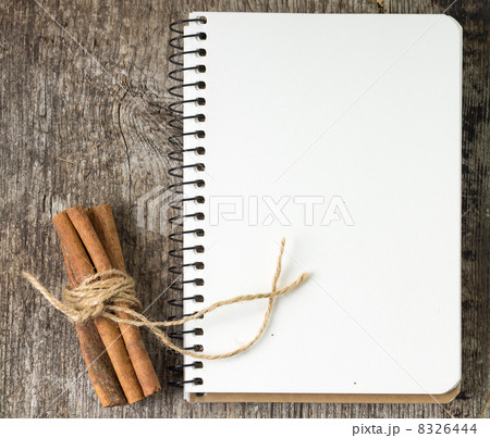 Blank Recipe book with bunch of cinnamon on old wood board 8326444