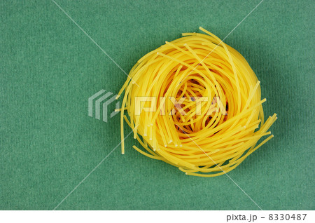 Tagliatelle pasta background on the green background 8330487