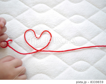 赤ちゃんの手と赤い糸の写真素材