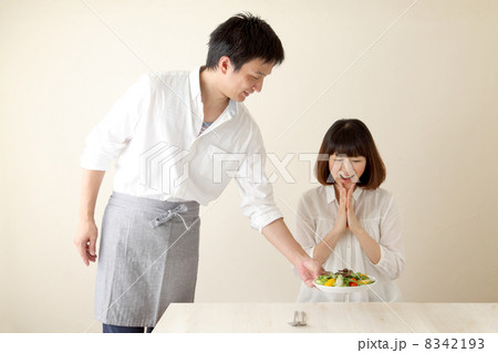 女性に料理を運ぶ男性 8342193