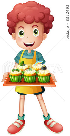 A young baker holding a tray with cupcakes A young baker holding a tray with cupcakes 8352493