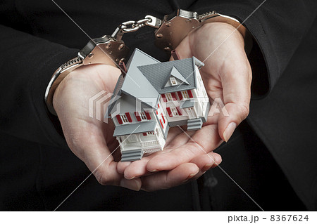 Woman In Handcuffs Holding Small House 8367624