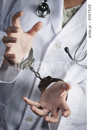 Doctor or Nurse In Handcuffs Wearing Lab Coat and Stethoscope 8367626