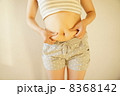 お腹をつまむ女性 8368142