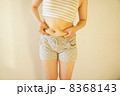 お腹をつまむ女性 8368143