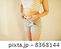 お腹をつまむ女性 8368144