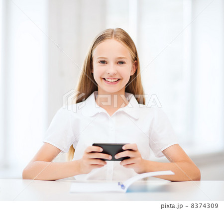 girl with smartphone at school girl with smartphone at school 8374309
