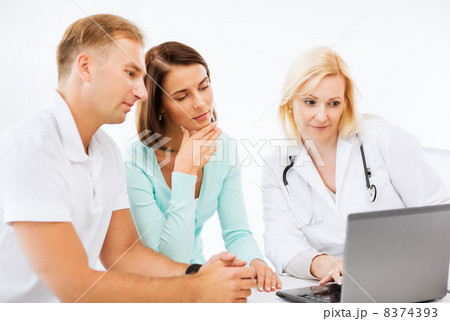 doctor with patients looking at laptop 8374393