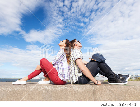 teenagers sitting back to back 8374441