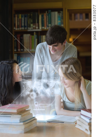 Happy students working together with futuristic interface 8383077