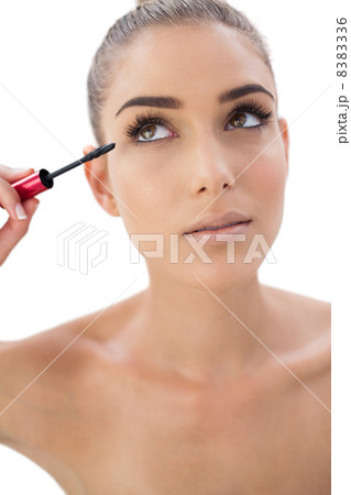 Pensive woman applying mascara Pensive woman applying mascara 8383336