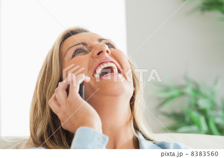 Laughing woman calling someone with her mobile phone Laughing woman calling someone with her mobile phone 8383560