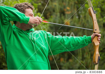 Man in green jumper about to shoot arrow 8383886