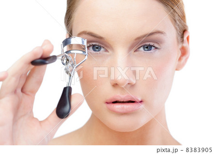 Pretty blonde model using eyelash curler 8383905