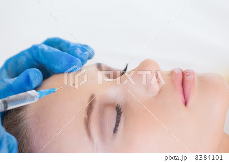 Surgeon making injection on natural woman lying 8384101