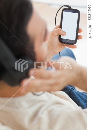 Close up on young man using his smartphone to listen to music Close up on young man using his smartphone to listen to music 8384540