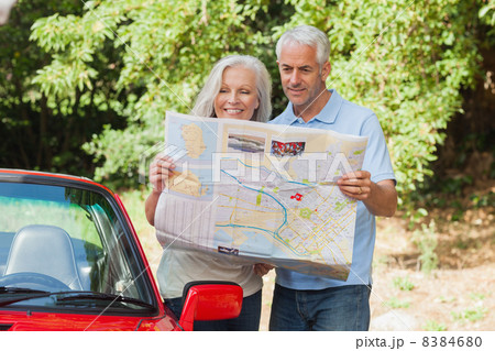 Smiling mature couple reading map 8384680