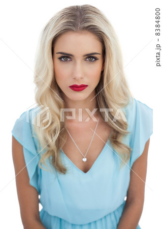 Severe blonde model in blue dress looking at camera 8384800