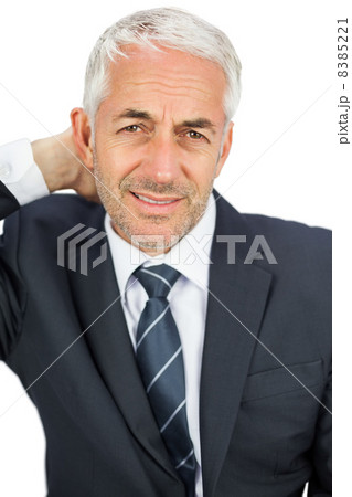 Businessman looking at camera touching his painful neck Businessman looking at camera touching his painful neck 8385221