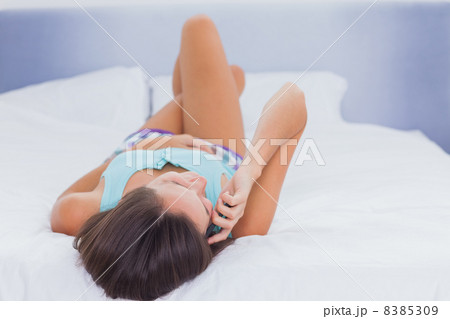 Woman on bed talking on phone Woman on bed talking on phone 8385309