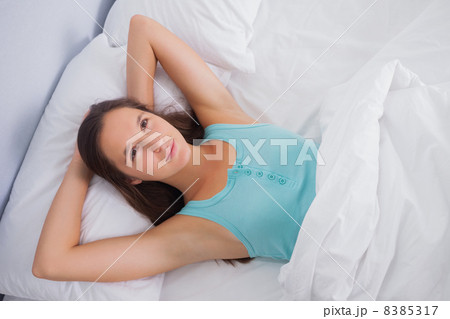 Charming woman relaxing lying on a bed 8385317