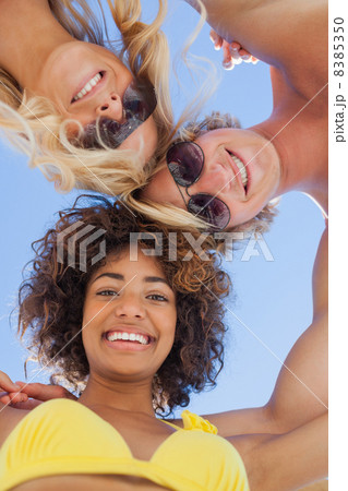 Low angle view of friends on beach 8385350