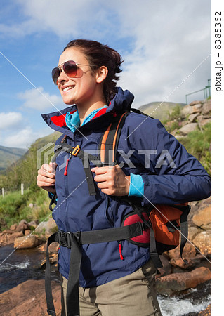 Brunette wearing rain jacket and sunglasses smiling 8385352