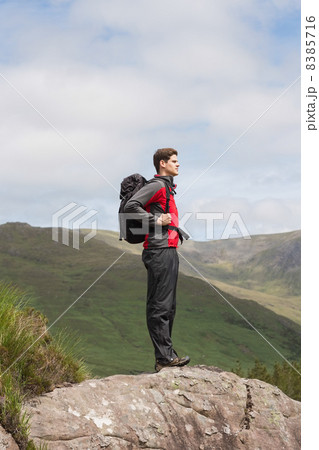 Handsome man standing at hill top admiring the view 8385716