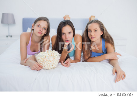 Friends eating popcorn and watching tv Friends eating popcorn and watching tv 8385737