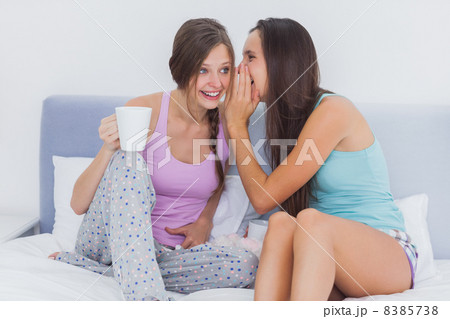 Friends sitting in bed gossiping Friends sitting in bed gossiping 8385738