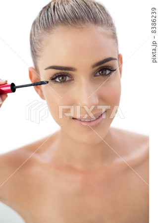 Smiling woman applying mascara 8386239