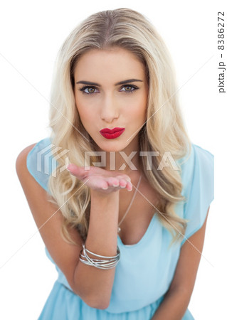 Seductive blonde model in blue dress sending a kiss to the camer Seductive blonde model in blue dress sending a kiss to the camer 8386272