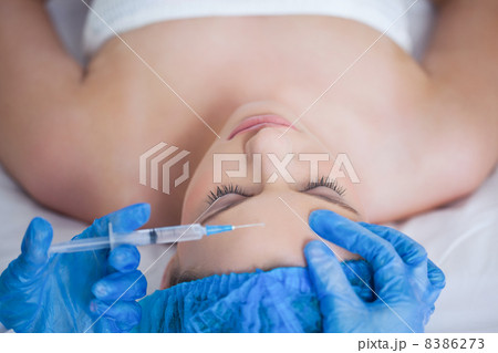 Surgeon making injection on woman lying Surgeon making injection on woman lying 8386273