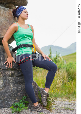 Attractive female rock climber leaning on rock face 8386275