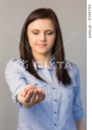 Cheerful pretty brunette presenting her empty hand Cheerful pretty brunette presenting her empty hand 8386704