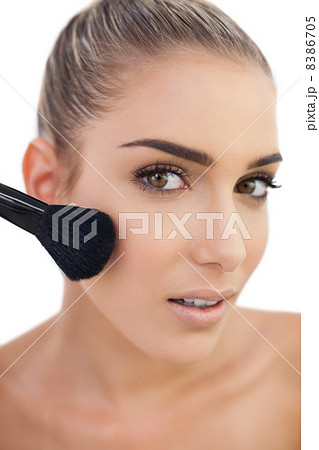 Surprised woman applying powder on her cheeks Surprised woman applying powder on her cheeks 8386705
