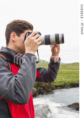 Brunette man on a hike taking a photograph 8386842