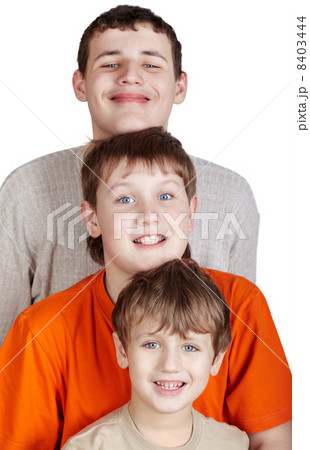 Three smiling boys stand one after another and putting own head Three smiling boys stand one after another and putting own head 8403444