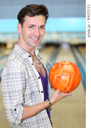 Young happy man wearing in white checkered shirt holds orange ba 8403511