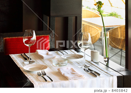 serving at table with white tablecloth and red chair in empty re 8403842