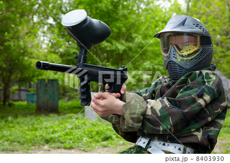 Paintball player in camouflage uniform and protective mask with 8403930