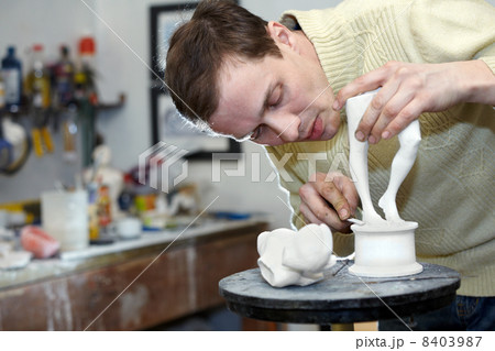 Sculptor works in the studio on a fragment of plaster sculpture. 8403987