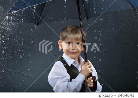 smiling boy dressed in white shirt and black vest standing under 8404043
