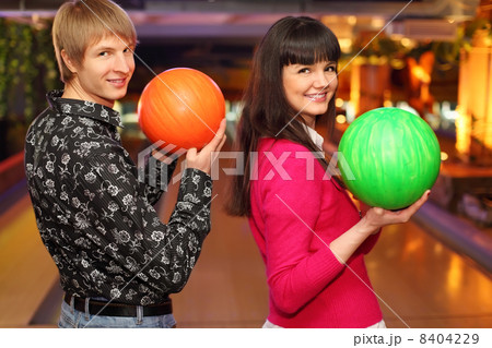 happy wife and husband with balls in bowling club stand sideways happy wife and husband with balls in bowling club stand sideways 8404229