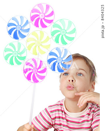 beautiful little girl blowing on big colorful toy windmill isola beautiful little girl blowing on big colorful toy windmill isola 8404325